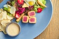 Fresh and healthy salad with grilled tuna, quail egg, tomatoes, potatoes and croutons. Traditional Nicoise Salad. CLose up. Wooden