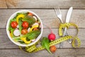 Fresh healthy salad and measuring tape. Healthy food Royalty Free Stock Photo