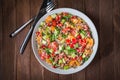 Fresh healthy salad with quinoa, colorful tomatoes, sweet pepper, cucumber and parsley on wooden background top view. Royalty Free Stock Photo