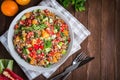 Fresh healthy salad with quinoa, colorful tomatoes, sweet pepper, cucumber and parsley on wooden background top view. Royalty Free Stock Photo