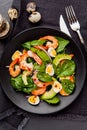 Fresh, healthy salad with shrimps, spinach and avocado on a black background. Top view. Royalty Free Stock Photo