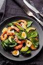 Fresh, healthy salad with shrimps, spinach and avocado on a black background. Top view. Royalty Free Stock Photo