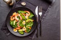 Fresh, healthy salad with shrimps, spinach and avocado on a black background. Top view. Royalty Free Stock Photo