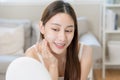 Fresh healthy skin, beautiful smile of asian young woman, girl looking at mirror, applying moisturizer on her face, putting cream Royalty Free Stock Photo