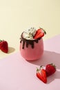 Fresh healthy strawberry smoothie with whipped cream and chocolate on colorful background. Summer dessert. Milkshake with banana