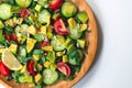 Fresh and healthy summer salad with cucumbers, tomatoes, avocado, arugula, sunflower seeds, lemons and chili flakes. Royalty Free Stock Photo