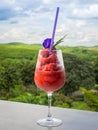 Fresh healthy watermelon smoothie in the glass against the background of sky, clouds, and mountains. Healthy nutrition and Royalty Free Stock Photo