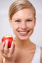 Fresh and healthy is the way to go. A portrait of a beautiful young woman eating a delicious red apple. Royalty Free Stock Photo