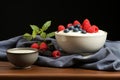 Yogurt and berry bowls with spoon and towel on bright white and yellow background, space for text