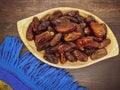 Fresh and healty premium honey tunisia dates kurma tunisia in a wooden bowl isolated on wooden table background Royalty Free Stock Photo