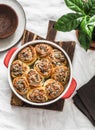 Fresh herb bread rolls with soft cream cheese in a baking dish on a wooden cutting board on light background top view. Appetizers