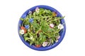 Fresh herb salad with leafy greens and nasturtium flowers served in a blue ceramic bowl on white Royalty Free Stock Photo