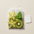 Fresh herbal tea concept with kiwi, starfruit, and mint in teabag on light background Royalty Free Stock Photo