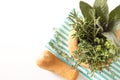 Fresh herbs bouquet in wooden mortar on folded kitchen towel, on white background. Royalty Free Stock Photo