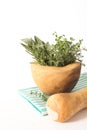 Fresh herbs bouquet in wooden mortar on folded kitchen towel, on white background. Royalty Free Stock Photo