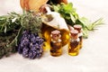 Fresh herbs from the garden and the different types of oils for massage and aromatherapy on table with lavender