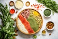 fresh herbs, seeds, and nuts surrounding a prepped raw pizza