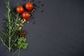 Fresh herbs and spices on dark slate background