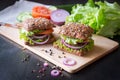 Fresh home made burgers with grain bread on wooden background Royalty Free Stock Photo