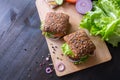 Fresh home made burgers with grain bread on wooden background Royalty Free Stock Photo