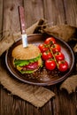 Fresh homemade beef burger on rustic wooden serving table with knife Selective focus Royalty Free Stock Photo