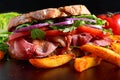 Fresh homemade BLT sandwich on grilled bread with bacon, lettuce, beef tomato, red onions, wild rocket and chips Royalty Free Stock Photo