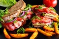 Fresh homemade BLT sandwich on grilled bread with bacon, lettuce, beef tomato, red onions, wild rocket and chips Royalty Free Stock Photo