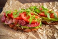 Fresh homemade BLT sandwich on grilled bread with bacon, lettuce, beef tomato, red onions, wild rocket and chips Royalty Free Stock Photo