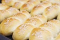 Fresh homemade bread rolls with sesam seed in basket on wooden t Royalty Free Stock Photo