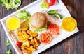 Fresh homemade burgers, fried potatoes, beer and juice served on white tray Royalty Free Stock Photo