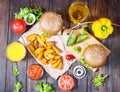 Fresh homemade burgers, fried potatoes, beer and juice served on wood table Royalty Free Stock Photo