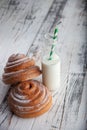Fresh homemade cinnamon rolls on a wooden cutting desk and milk in glass bottle Royalty Free Stock Photo