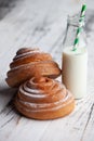 Fresh homemade cinnamon rolls on a wooden cutting desk and milk in glass bottle Royalty Free Stock Photo