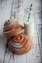 Fresh homemade cinnamon rolls on a wooden cutting desk and milk in glass bottle Royalty Free Stock Photo