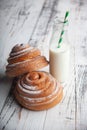 Fresh homemade cinnamon rolls on a wooden cutting desk and milk in glass bottle Royalty Free Stock Photo