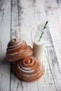 Fresh homemade cinnamon rolls on a wooden cutting desk and milk in glass bottle Royalty Free Stock Photo