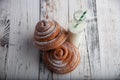 Fresh homemade cinnamon rolls on a wooden cutting desk and milk in glass bottle Royalty Free Stock Photo