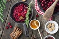 Fresh homemade cranberry sauce in a pan on dark wooden background with scattering of ripe berries. Royalty Free Stock Photo