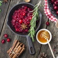 Fresh homemade cranberry sauce in a pan on dark wooden background with scattering of ripe berries. Royalty Free Stock Photo