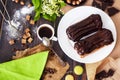 Fresh homemade eclairs with chocolate on the kitchen table. French pastries