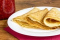 Fresh homemade folded crepe filled with strawberry jam on plate