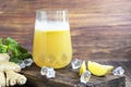 Fresh homemade ginger beer cocktail. Ice and lime on the table. On a wooden brownbackground.