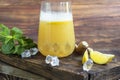 Fresh homemade ginger beer cocktail. Ice and lime on the table. On a wooden brownbackground.