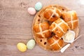 Fresh homemade Hot Cross Buns on a wooden plate