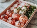 Fresh Homemade Japanese Onigiri with Salmon and Tuna in a Bento Box on Marble Background