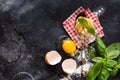 Fresh homemade pasta tagliatelle on wooden spoon with pasta ingredients tomatoes, raw egg, basil leaf on the dark concrete backgro Royalty Free Stock Photo