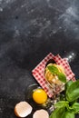 Fresh homemade pasta tagliatelle on wooden spoon with pasta ingredients tomatoes, raw egg, basil leaf on the dark concrete backgro Royalty Free Stock Photo