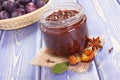 Fresh plum marmalade in jar, spices and ripe fruits in wicker basket, healthy sweet dessert Royalty Free Stock Photo