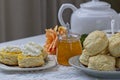 Freshly baked scones with homemade apricot jam topped with whipped cream