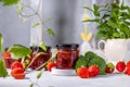 Fresh homemade strawberry jam in glass jar on a light background